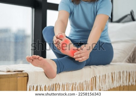 Joint diseases, hallux valgus, plantar fasciitis, heel spur, woman's leg hurts, pain in the foot, massage of female feet at home, health problems concept Royalty-Free Stock Photo #2258156343