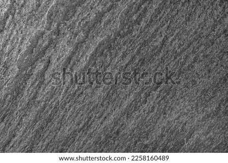 Surface of slate stone plate of layers, dark background, close-up top view, wallpaper, uniform texture pattern