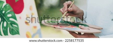 Female artist painting art canvas drawing with inspiration in garden art therapy creativity concept.