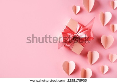 Pink gift box with bow on pink background, valentines and mothers day concept, card, copy space, top view