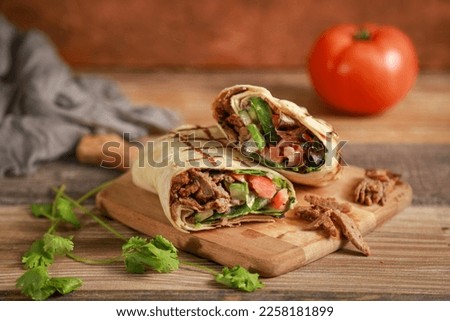 Beef shawarma sandwich fresh roll, wrap of grilled meat and salad tortilla wrap with white sauce. turkish Doner Kebab on a lavash - Shawarma Beef.
 Royalty-Free Stock Photo #2258181899