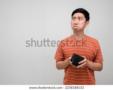 Asian man orange striped feels sad with no money in wallet isolated,Poor man unhappy about not enought money Royalty-Free Stock Photo #2258188153