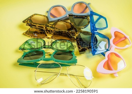 Glasses concept. Set of glasses with different eyeglass frame and transparent lenses on yellow background top view copy space