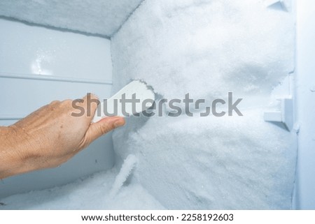 remove the ice from the freezer at home Royalty-Free Stock Photo #2258192603