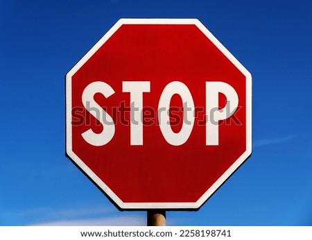 STOP ROAD SIGN WITH A BLUE SKY BACKGROUND