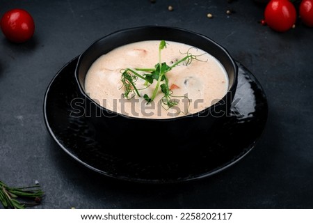 Potato soup puree on a dark background. Potato cream soup with champignons, carrots and microgreens in bowl. Vegetarian healthy food.