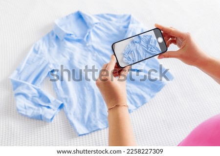 Woman taking photo of her used clothes in order to sell them online