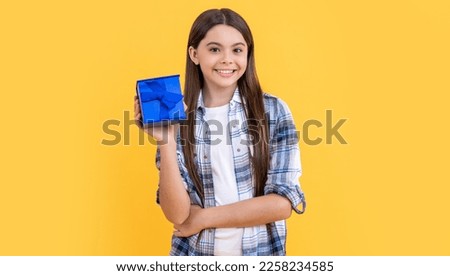 positive teen girl with birthday gift in studio. teen girl with birthday gift on background