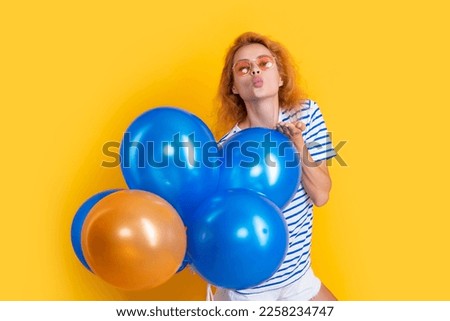 party girl with balloon in sunglasses. happy girl blowing kiss hold party balloons in studio
