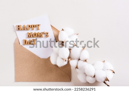 Happy mother's day. Envelope with a sheet of paper, letters and a branch of cotton on a light background.