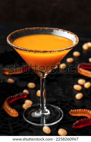 Fresh pumpkin juice or cocktail on  dark Halloween background, selective focus with shallow depth of field