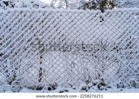 Wire fence in the snow. Winter background with selective focus