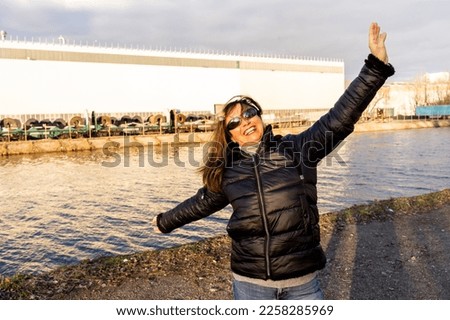 middle aged woman wearing winter clothes taking fun by a river - people in recreation concept