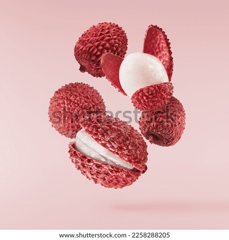 Fresh ripe red lychee falling in the air isolated on pink background. Food levitation or zero gravity conception. High resolution image Royalty-Free Stock Photo #2258288205