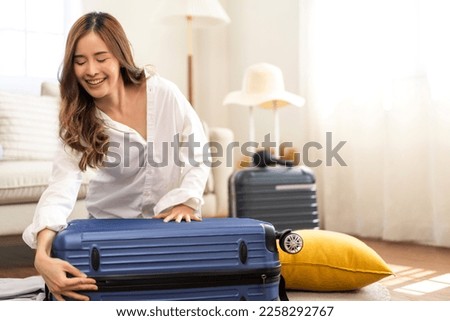 Portrait of beauty asian traveler woman packing stuff and outfit clothes in suitcases travel bag luggage for summer holiday weekend tourist vacation trip at home. travel concept Royalty-Free Stock Photo #2258292767