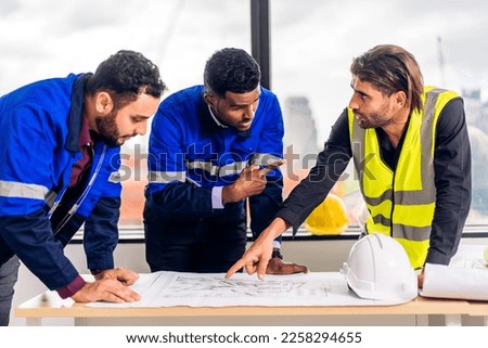Professional of team architect industrial engineer cargo foreman in helmet working new construction project architectural plan with blueprint and construction tool at building construction site