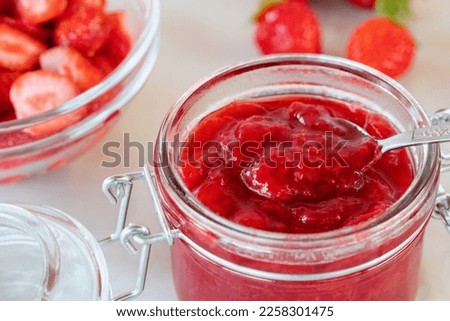 Preparation and preservation of strawberry jam in a glass jar, close up
