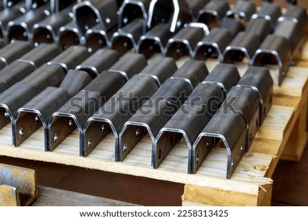 Bent metal products are stacked on a pallet. Work with sheet metal. Royalty-Free Stock Photo #2258313425