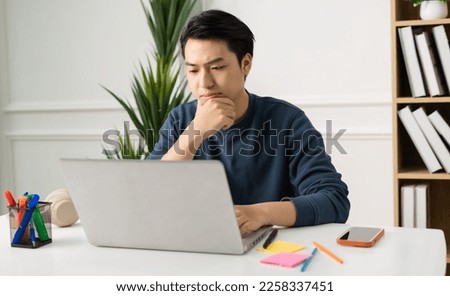 image of Asian man sitting at home working