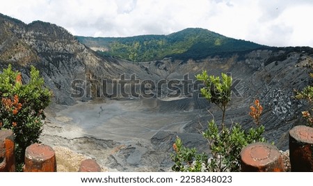 The crater of Mount Tangkuban Perahu, in Indonesia Surrounded by large cliffs and rocks adds to the dramatic effect.