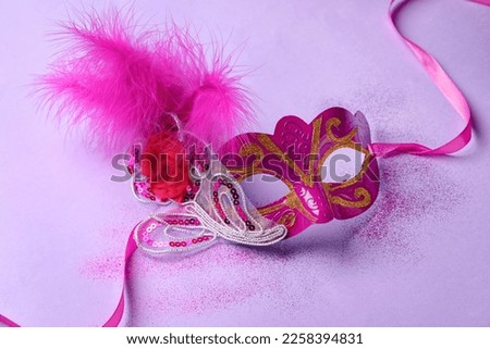 Carnival mask for Mardi Gras celebration with glitter on lilac background