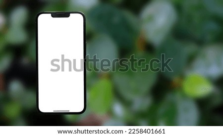 white empty mobile phone screen template mockup for product app ads concept on green leaves nature.