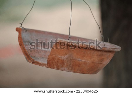 a hanging broken pot on a tree 