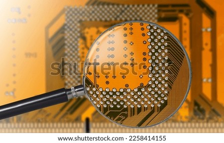 view of printed circuit board with active and passive surface mounted components close up through magnifying glass Royalty-Free Stock Photo #2258414155