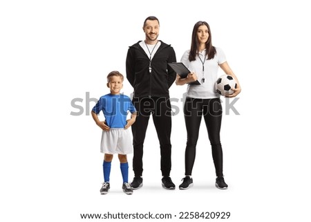 Boy posing next to a football coach and a female assistant isolated on white background