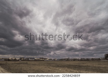 Heavy storm clouds above countryside landscape photo. Beautiful nature scenery photography with blurred background. Idyllic scene. High quality picture for wallpaper, travel blog, magazine, article