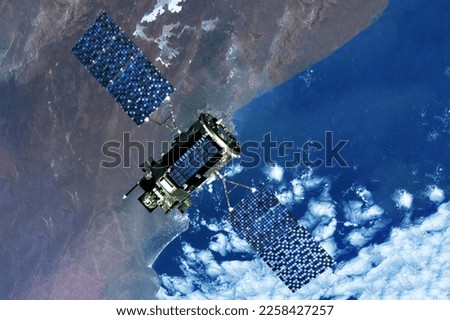 Space communications satellite above the earth. Elements of this image furnished by NASA. High quality photo