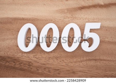 White number 0005 on a brown and light brown wooden background.