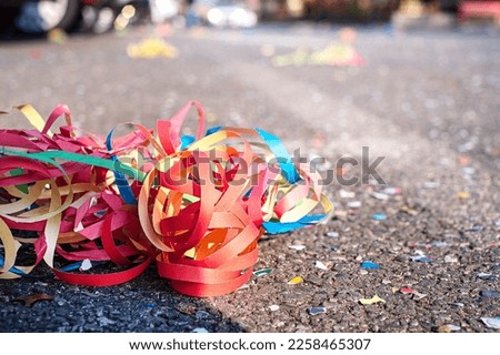 Close up colorful confetti and streamers at the street after Carnival parade Royalty-Free Stock Photo #2258465307