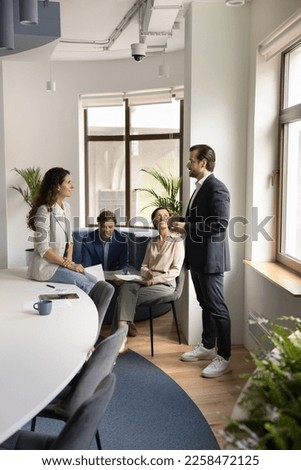 Business project leader man talking to employee on brief meeting, instructing worker. Expert giving consultation to office team. Couple of coworkers discussing work tasks during break. Royalty-Free Stock Photo #2258472125