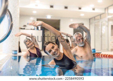 Senior adults in the swimming pool during aqua aerobics class Royalty-Free Stock Photo #2258490593