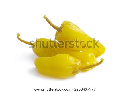Three pickled yellow peppers, pepperoncini or friggitelli isolated on white background. Hot pepper marinated, brined. Traditional Italian and greek cuisine, ingredient for salad, pasta, sauce. Royalty-Free Stock Photo #2258497977