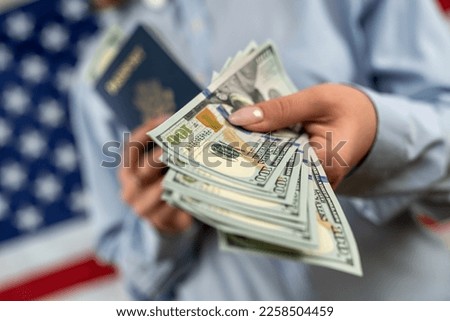 tourist woman on vacation holding United States passport with dollars very happy and excited. woman with passport and dollars in front of usa flag. travel concept