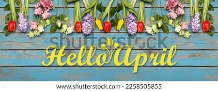 Banner with text HELLO, APRIL and flowers on wooden background Royalty-Free Stock Photo #2258505855