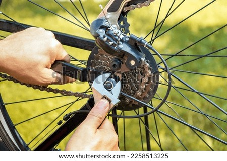 A mechanic repairs a bike on the street with a wrench. Close-up of the master hands during urgent repairs.