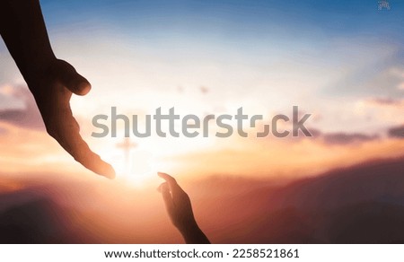 Silhouettes of hands reaching out for hope and supporting each other on sunset background.