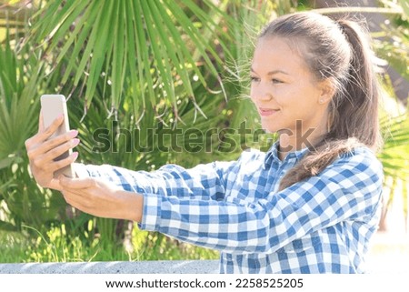 Young girl taking a selfie in a park