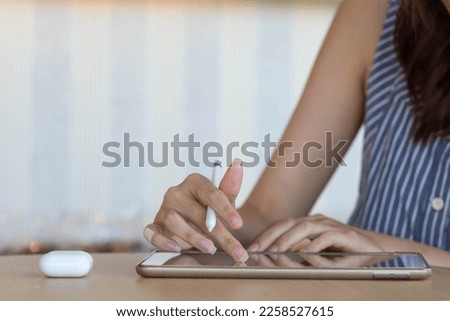 Young woman holding a stylus in her hand to use along with application in tablet to test and develop ux ui system and to design application that can work efficiently with perfect ux ui system.