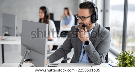 Handsome male customer support executive agent working at call centre Royalty-Free Stock Photo #2258531635