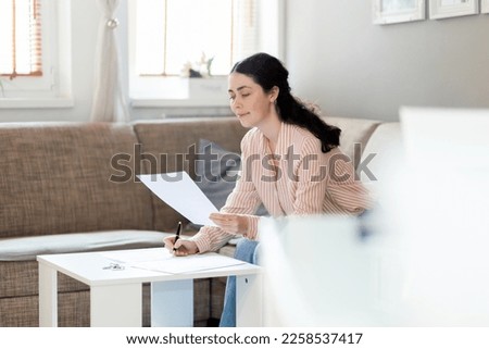 Purchase of real estate. Young caucasian woman watching documents in office. Copy space. Concept of leasing, business and mortgage.