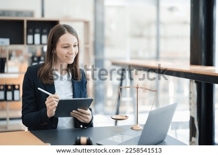 Portrait of a Asian woman lawyer studying lawsuit a for a client using tablet computer  to work before going to court