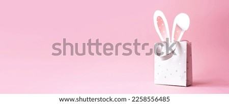 Easter bunny ears in a paper bag. Pink background. Space for text. Happy easter