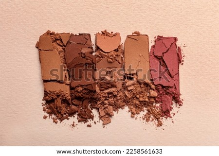 Different crushed eye shadows on beige background, flat lay Royalty-Free Stock Photo #2258561633