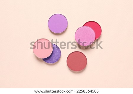 Different beautiful eye shadows on beige background, flat lay Royalty-Free Stock Photo #2258564505