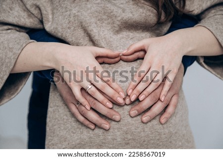 Appearance of firstborn. First birth. Pregnancy. Hands rest on pregnant belly