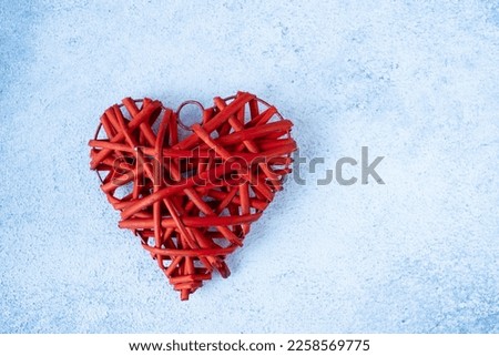 red braided heart on a light background. The concept of Valentine's Day, top view , the place under the text